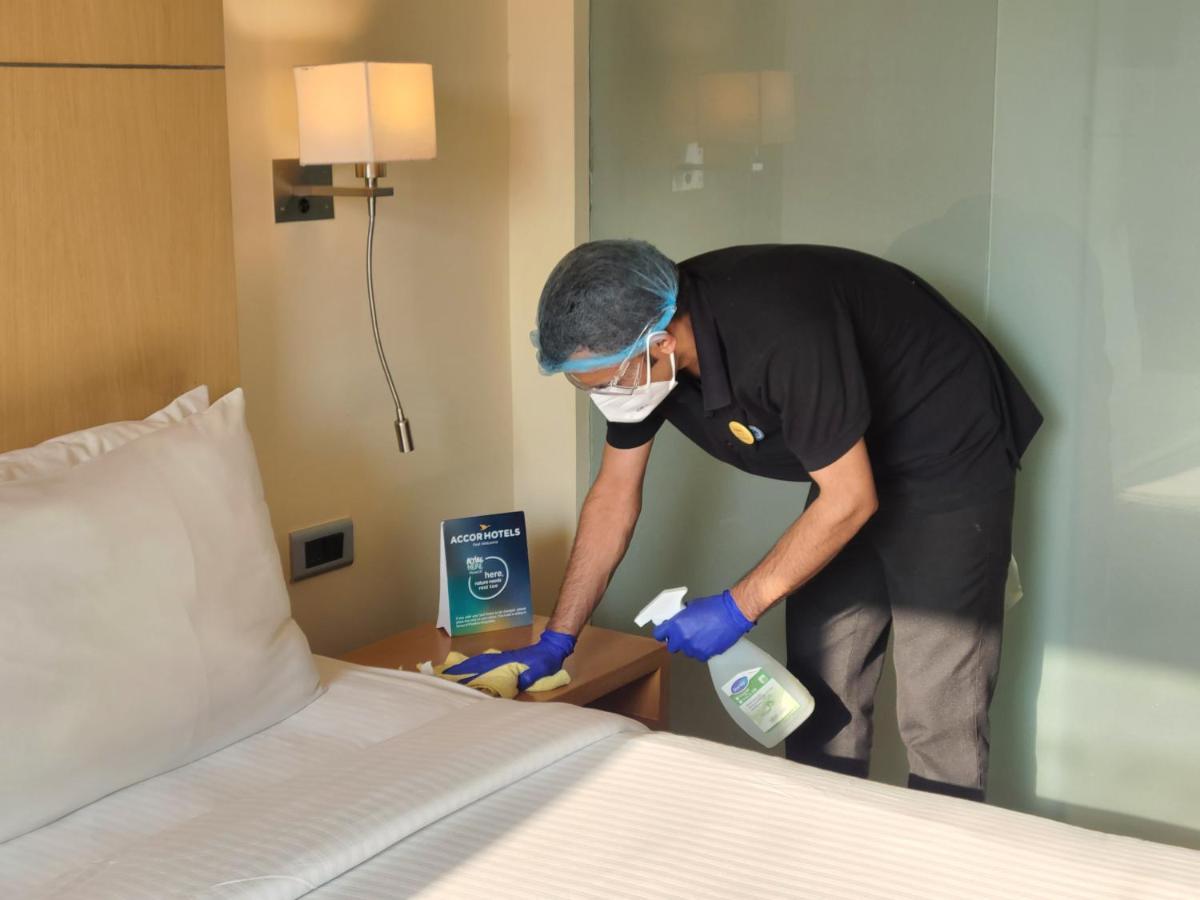 Novotel Hyderabad Airport Екстер'єр фото A hotel employee cleans a guest room.